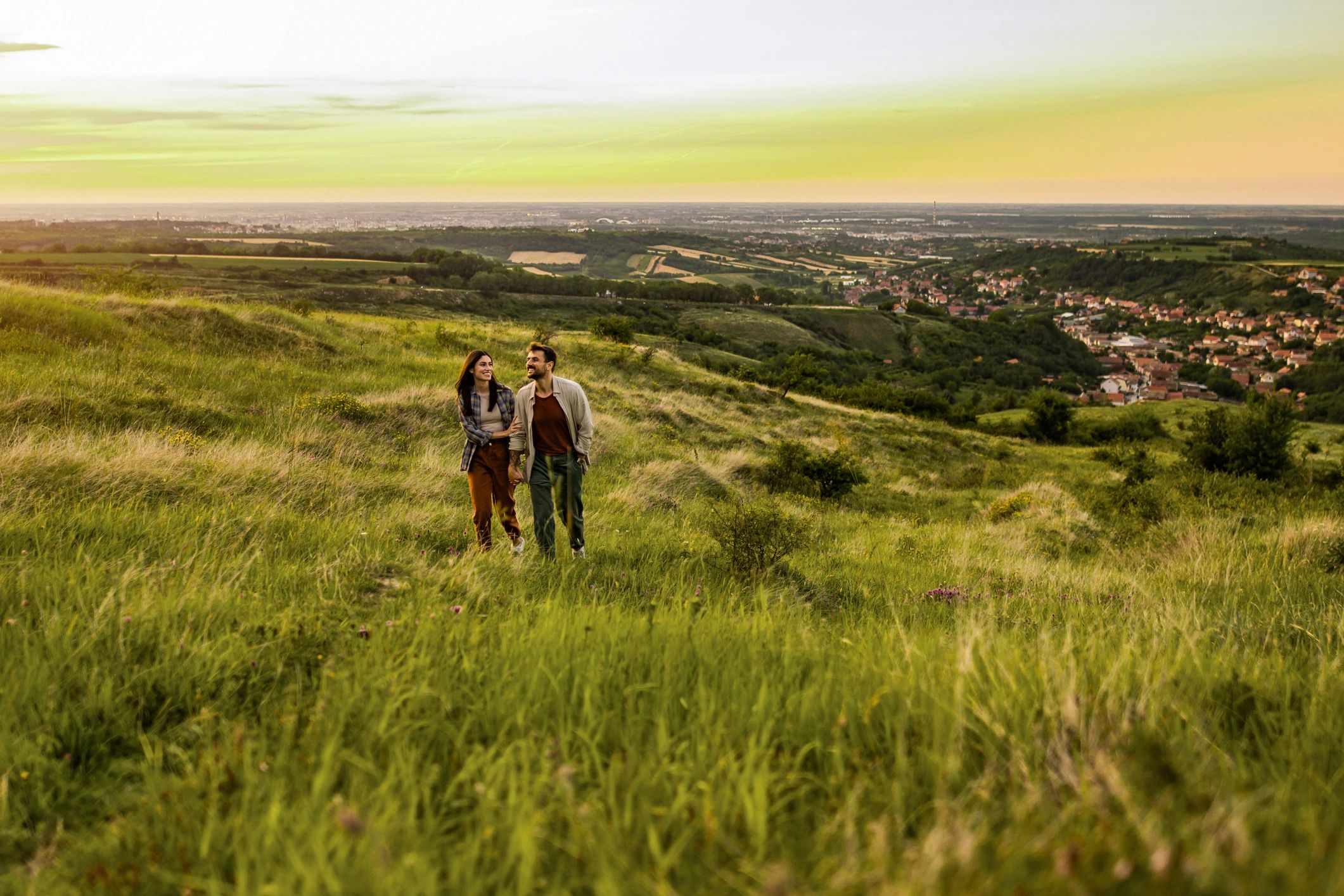 Couple walking in a field at sunset