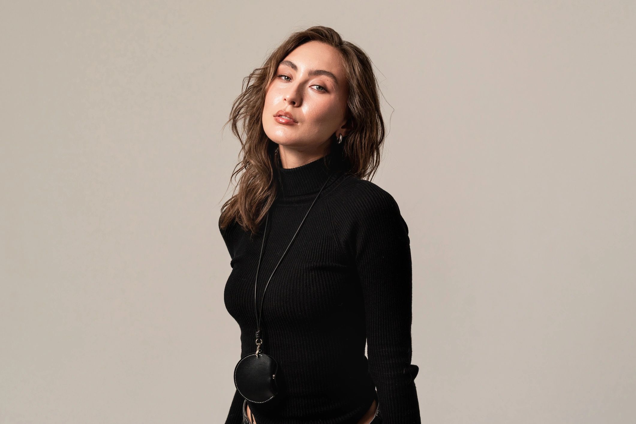 Portrait of a woman in a black turtleneck on a neutral background