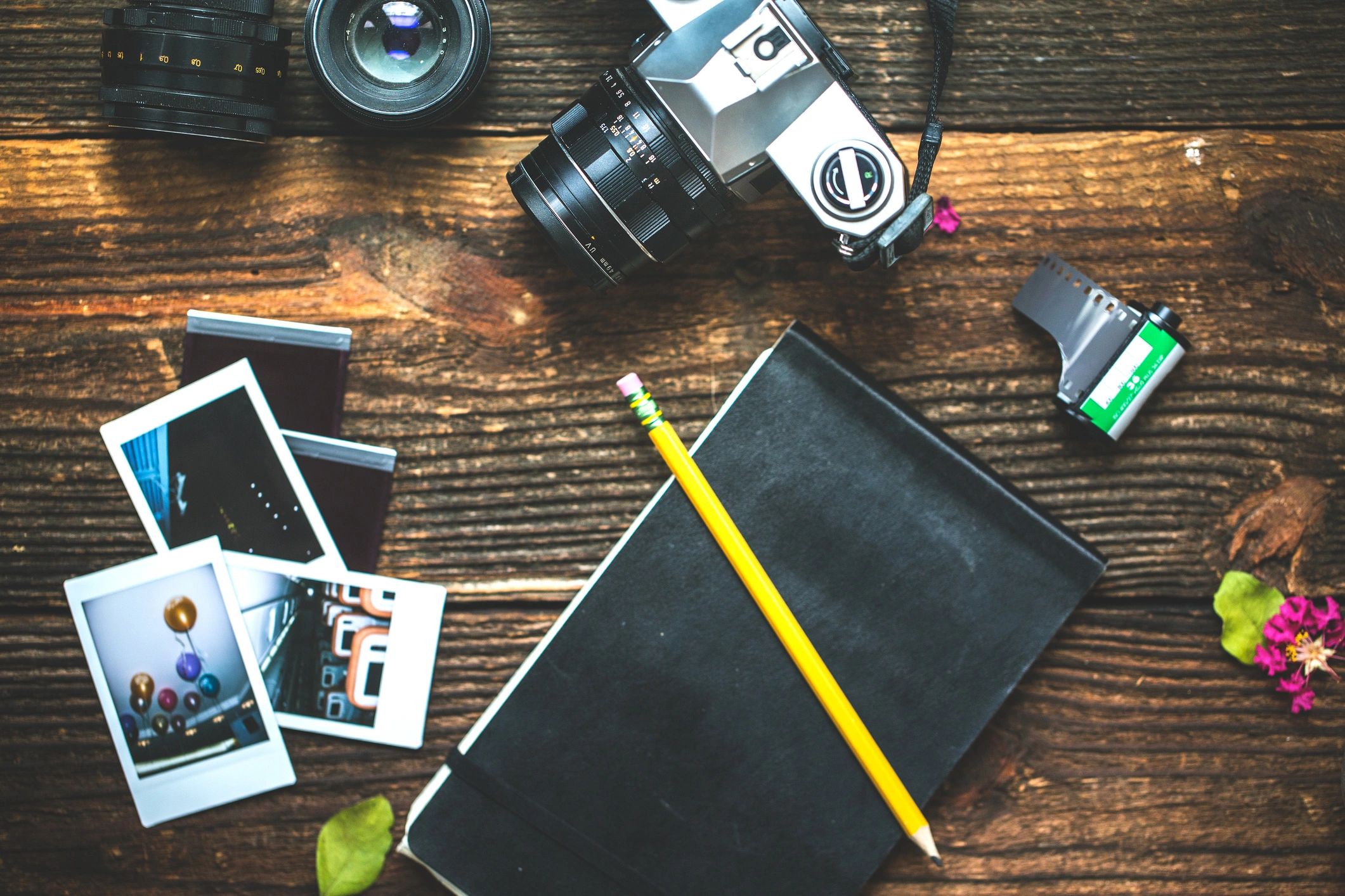 Camera and photographer accessories arranged on a dark tabletop